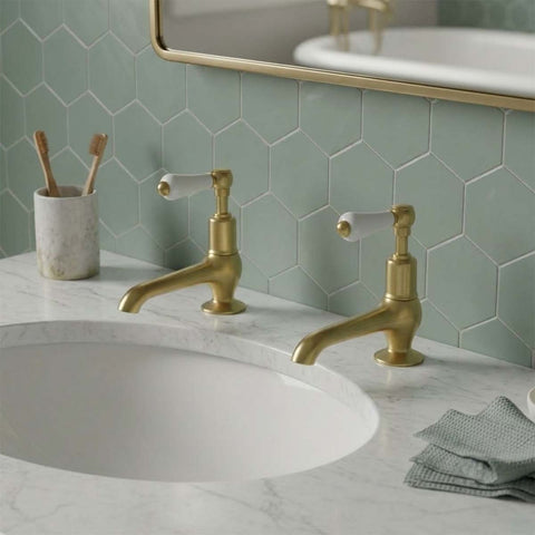 traditional brushed brass basin pillar taps with white ceramic handles 